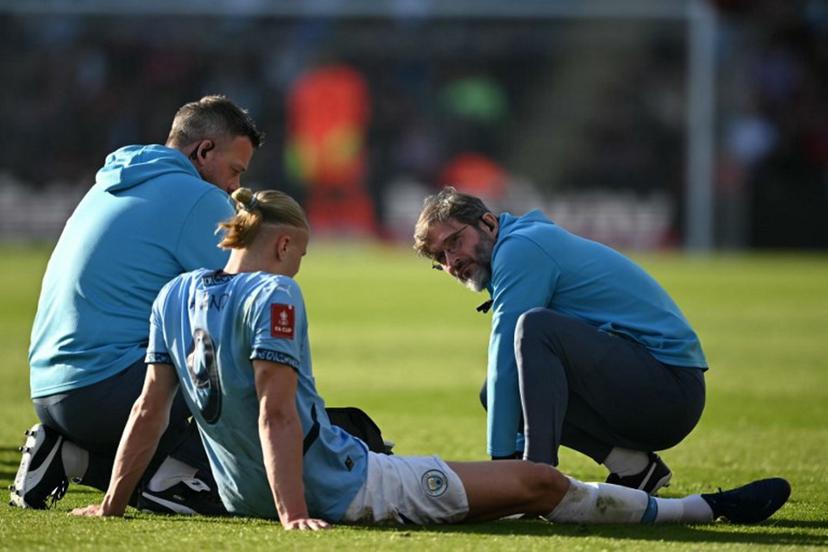 Manchester City's Norwegian striker #09 Erling Haaland receives medical attention after picking up an injury during the English FA Cup quarter-final football match between Bournemouth and Manchester City at the Vitality Stadium in Bournemouth, on the south coast of England on March 30, 2025.  JUSTIN TALLIS / AFP