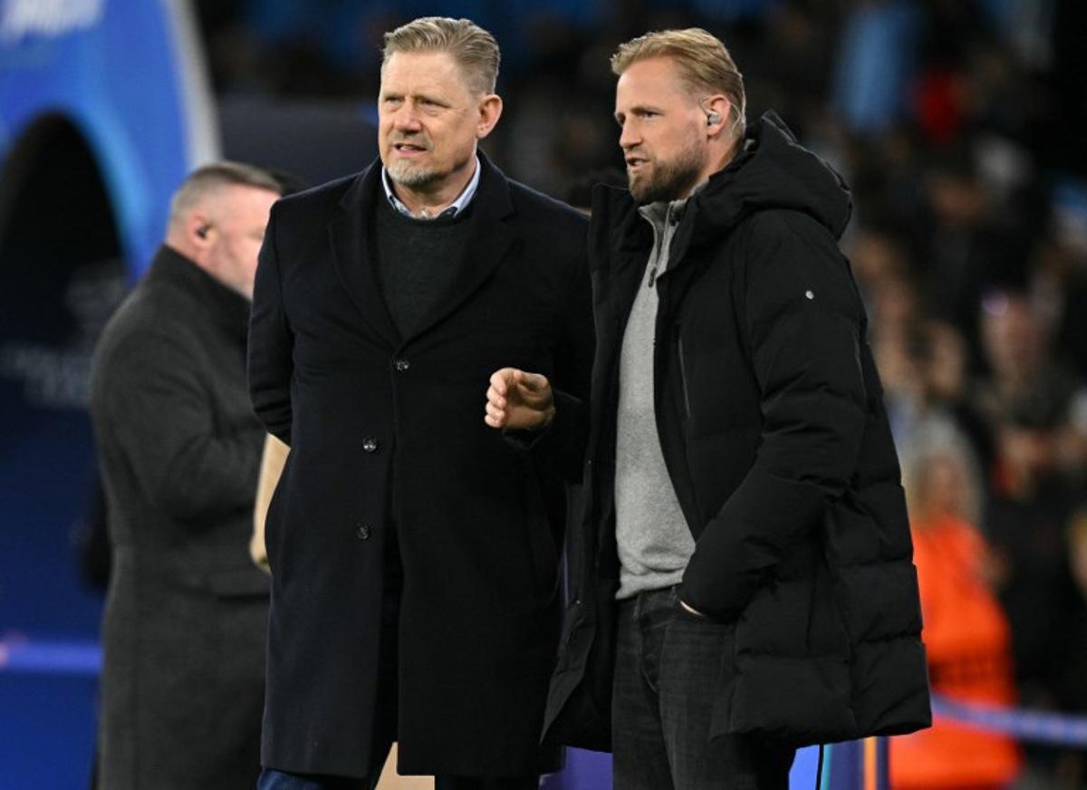Danish former footballer Peter Schmeichel (L) talks with his son Kasper Schmeichel ahead of the UEFA Champions League, round of 16 second leg football match between Manchester City and Real Madrid at the Etihad Stadium in Manchester, north west England, on March 17, 2026.  Oli SCARFF / AFP