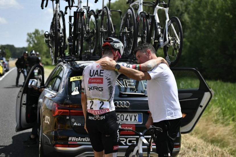 UAE Team Emirates - XRG team's Portuguese rider Joao Almeida is comforted by a team staffed member as he prepared to board his team support vehicle after withdrawing from the race on injury, during the 9th stage of the 112th edition of the Tour de France cycling race, 174.1 km between Chinon and Chateauroux, central France, on July 13, 2025.  Marco BERTORELLO / AFP