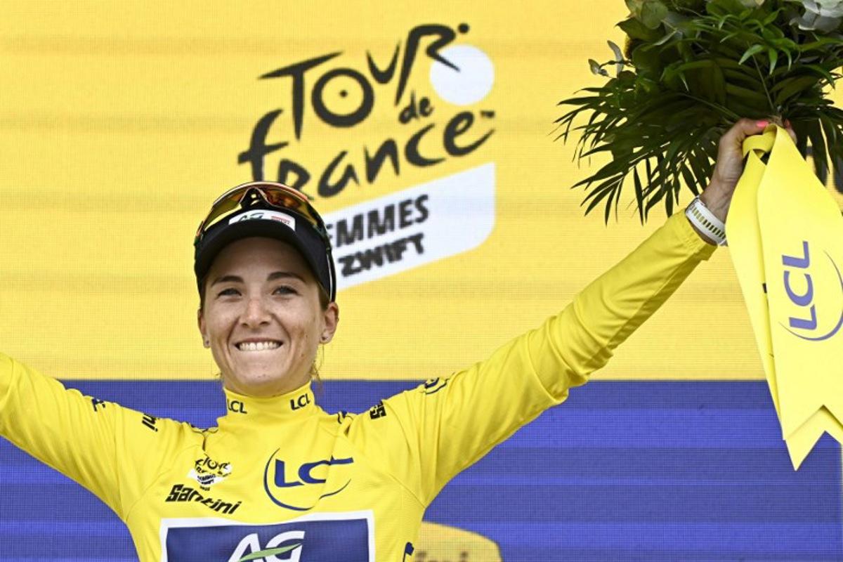 AG Insurance - Soudal Team's Mauritius rider Kimberley Le Court Pienaar celebrates on the podium with the overall leader's yellow jersey after the 2nd stage (out of 9) of the fourth edition of the Women's Tour de France cycling race, 110,4 km from Brest to Quimper on July 27, 2025.  JULIEN DE ROSA / AFP