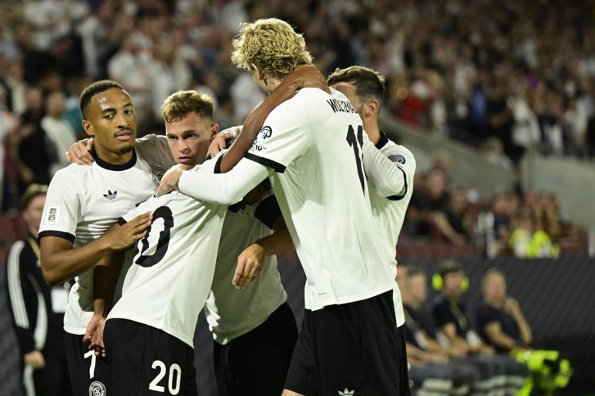 Germany's midfielder #20 Serge Gnabry (2nd L) celebrates with team players after scoring the opening 1-0 goal during the 2026 World Cup qualifiers Europe zone group A football match between Germany and Northern Ireland on September 7, 2025 in Cologne, western Germany.  INA FASSBENDER / AFP