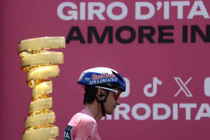 Red Bull-Bora-Hansgrohe's Slovenian rider Primoz Roglic, wearing the pink jersey (Maglia Rosa), walks past the Giro d'Italia trophy ("trofeo senza fine") during the presentation prior to the 3th stage of the 108th Giro d'Italia cycling race 160kms from Vlore to Vlore in Albania on May 11, 2025.  Luca Bettini / AFP