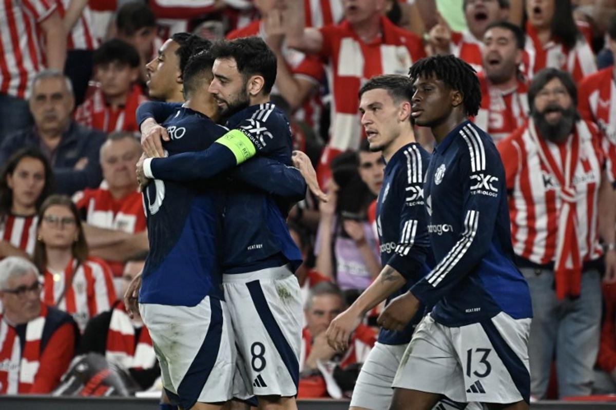 Manchester United's Portuguese midfielder #08 Bruno Fernandes celebrates with teammates after scoring their second goal during the UEFA Europa League semi final first leg football match between Athletic Club Bilbao and Manchester United at the San Mames stadium in Bilbao, on May 1, 2025.  ANDER GILLENEA / AFP