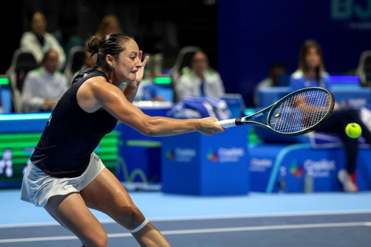 Italy's Elisabetta Cocciaretto hits a return to Ukraine's Marta Kostyuk during their first singles semi-final match between Italy and Ukraine at the Billie Jean King Cup in Shenzhen, southern China's Guangdong province on September 19, 2025.  STR / AFP