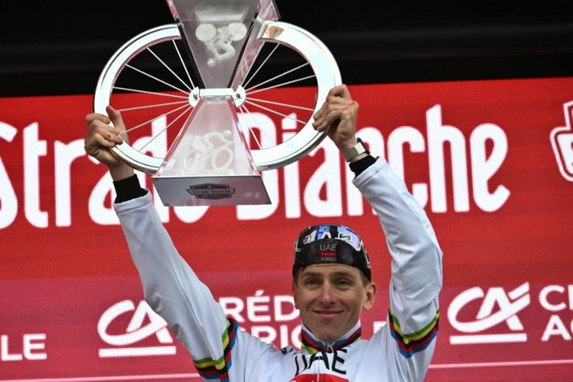 Team UAE's Slovenain rider Tadej Pogacar celebrates as he holds his trophy on the podium after winning the 19th one-day classic 'Strade Bianche' (White Roads) men's cycling race between Siena and Siena in Tuscany on March 8, 2025.   Marco BERTORELLO / AFP