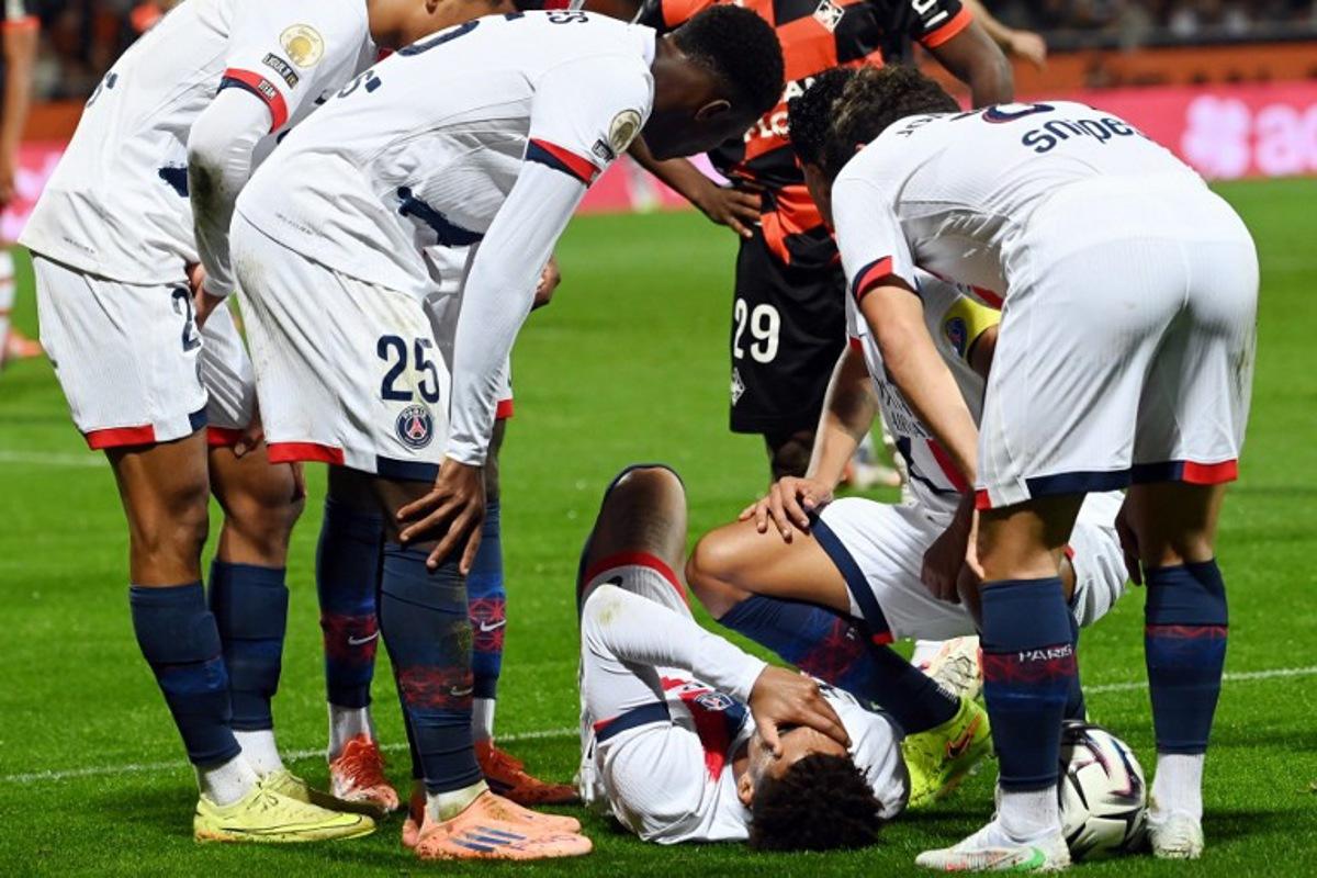 Paris Saint-Germain's French midfielder #14 Desire Doue (C) reacts in pain after suffering an injury during the French L1 football match between FC Lorient and Paris Saint-Germain (PSG) at the Stade du Moustoir in Lorient, western France, on October 29, 2025.  JEAN-FRANCOIS MONIER / AFP