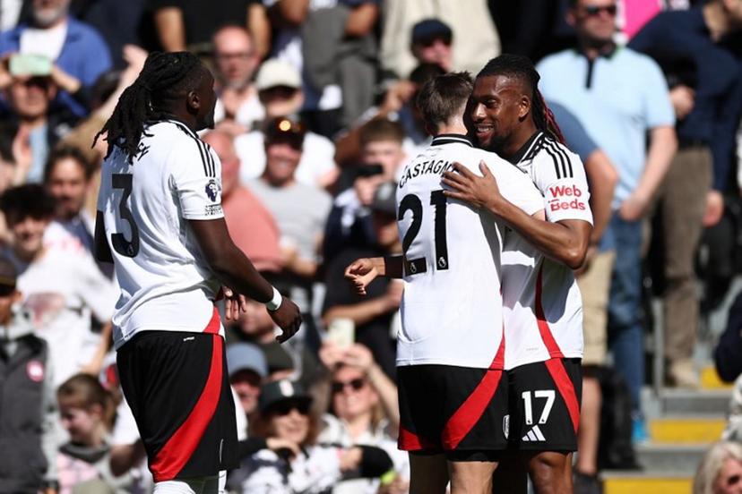 Fulham's Nigerian midfielder #17 Alex Iwobi (R) celebrates with teammates after scoring their second goal during the English Premier League football match between Fulham and Liverpool at Craven Cottage in London on April 6, 2025.  HENRY NICHOLLS / AFP