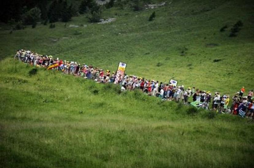Fans wait for riders in the Col des Saisies pass during the 204,5 km and 9th stage of the 201 Tour de France cycling race run between Morzine Avoriaz ski resort and Saint-Jean de Maurienne, in Savoy, on July 13, 2010.   AFP PHOTO / LIONEL BONAVENTURE