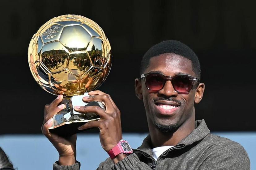 Paris Saint-Germain's French forward Ousmane Dembele holds the 2025 Ballon d'Or trophy during a presentation ceremony at the City Hall in Evreux, his hometown and where he started playing club football, on October 12, 2025.  LOU BENOIST / AFP