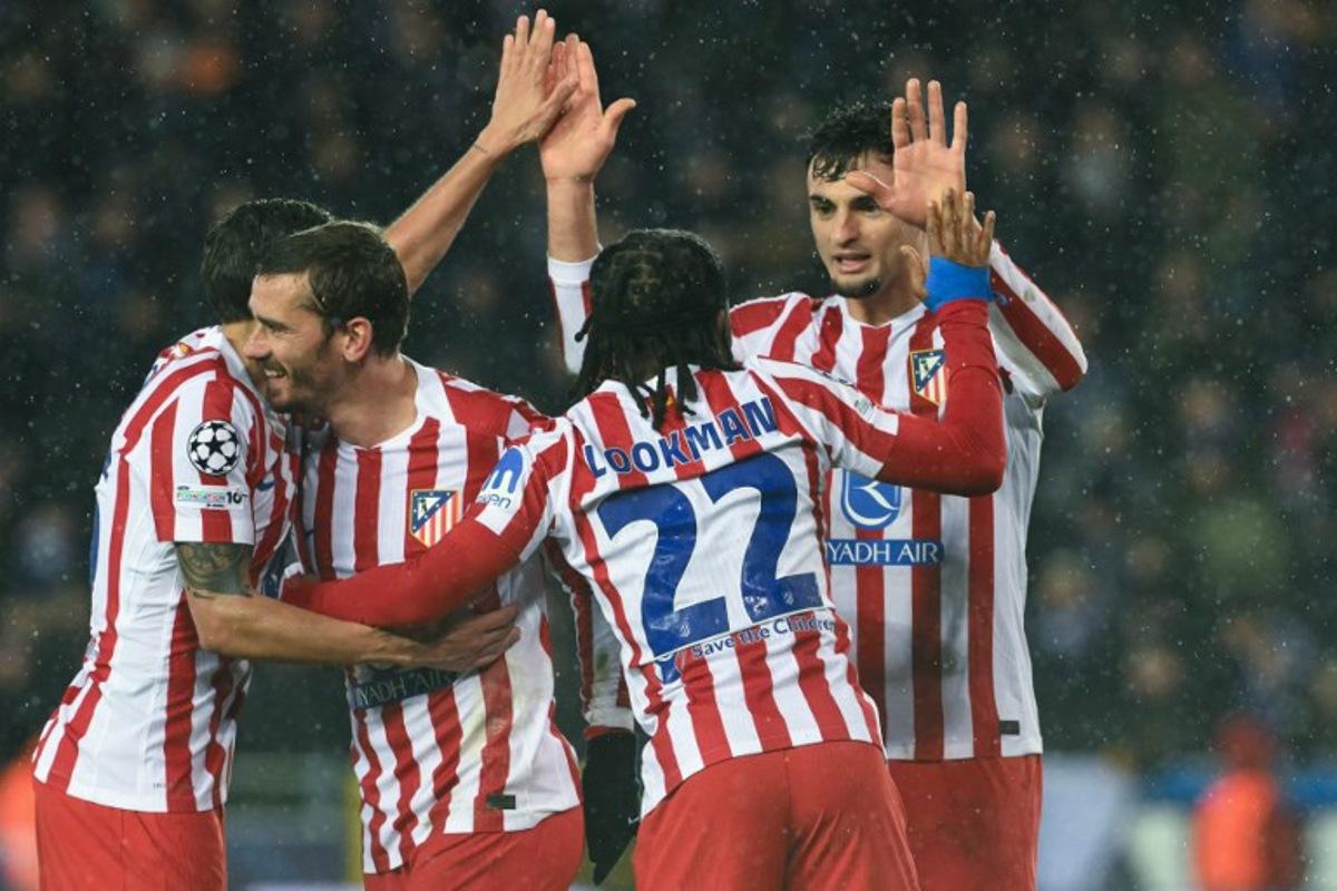 Atletico Madrid's Nigerian forward #22 Ademola Lookman celebrates with teammates after scoring his team's second goal during the UEFA Champions League knockout round play-off first leg football match between Club Brugge and Atletico Madrid at the Jan Breydel Stadium in Brugge on February 18, 2026.  NICOLAS TUCAT / AFP