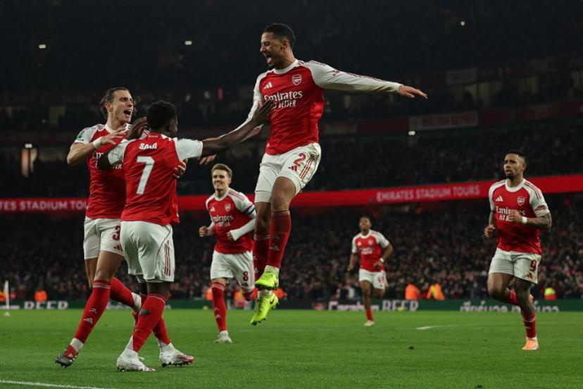 Arsenal's French defender #02 William Saliba (C) celebrates the team's opening goal, an own goal by Crystal Palace's French defender #05 Maxence Lacroix (unseen) during the English League Cup quarter-final football match between Arsenal and Crystal Palace at the Emirates Stadium, in London on December 23, 2025.  Adrian Dennis / AFP