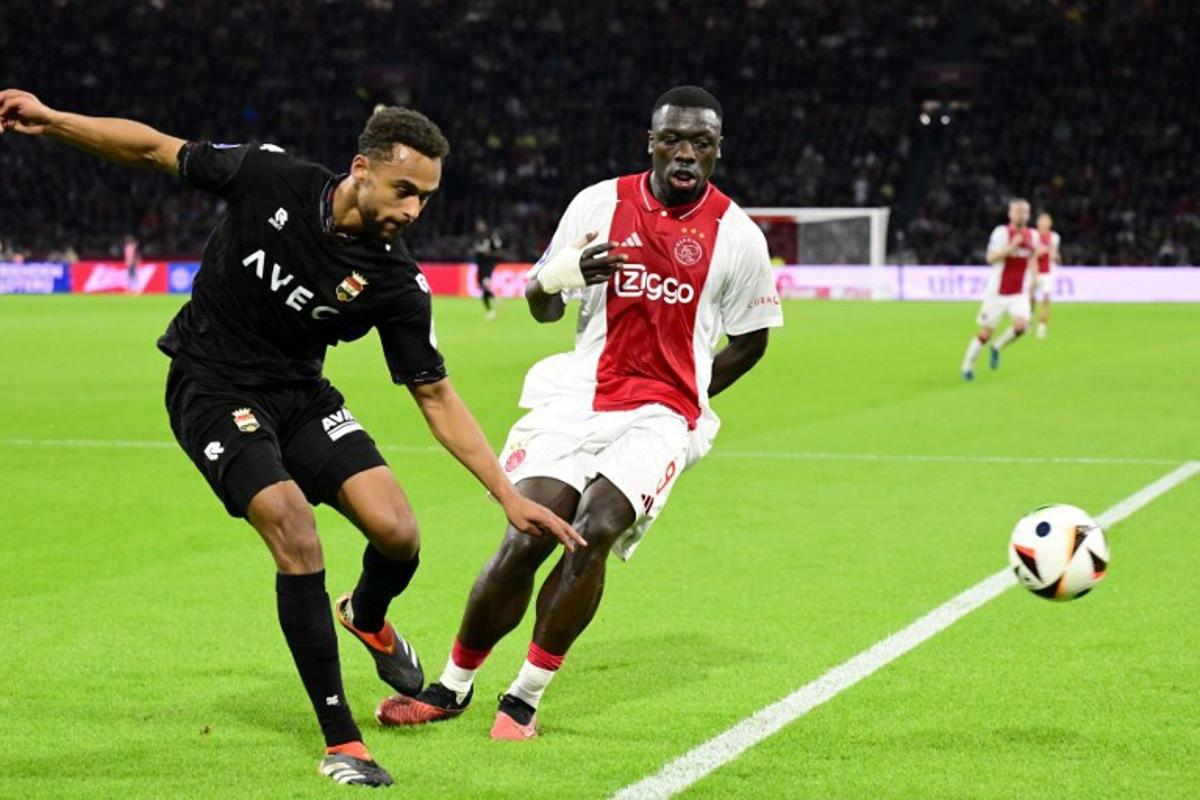 Willem II's Dutch defender #33 Tommy St. Jago (L) fights for the ball with Ajax's Dutch forward #09 Brian Brobbey (C) during the Dutch Eredivisie match between Ajax Amsterdam and Willem II at the Johan Cruyff Arena, in Amsterdam, on October 27, 2024.  Olaf Kraak / ANP / AFP