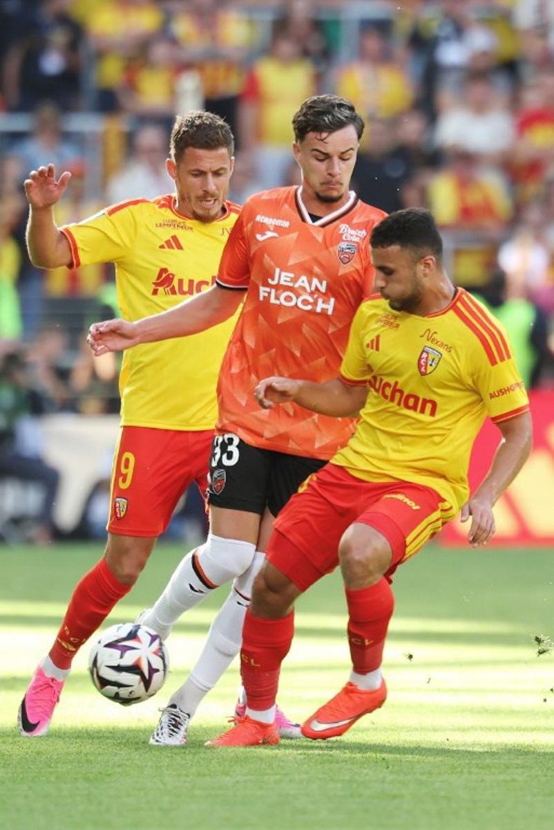 Lens' Belgian midfielder #09 Thorgan Hazard (L) and Lens' Algerian midfielder #08 Yacine Titraoui (R) fight for the ball with Lorient's French midfielder #33 Gabin Bernardeau (C) during the French L1 football match between RC Lens and FC Lorient at the Stade Bollaert-Delelis in Lens, northern France, on September 5, 2026.  Francois LO PRESTI / AFP