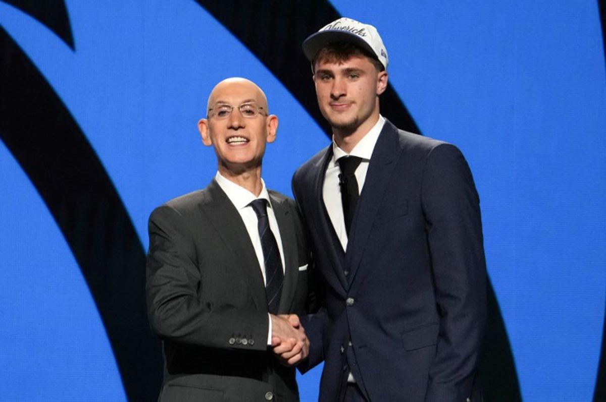 US basketball player Cooper Flagg (R) shakes hands with NBA Commissioner Adam Silver after being selected first overall by the Dallas Mavericks during the opening round of the 2025 NBA Draft at Barclays Center in Brooklyn, New York, on June 25, 2025. Versatile US college teen star Cooper Flagg was selected first overall in the NBA draft on June 25 by the Dallas Mavericks, where he'll join a star-laden team already touted as a playoff threat next season. Flagg, a consensus pick as the top US college player as a freshman at Duke University last season, is the second-youngest player taken first overall.  TIMOTHY A. CLARY / AFP
