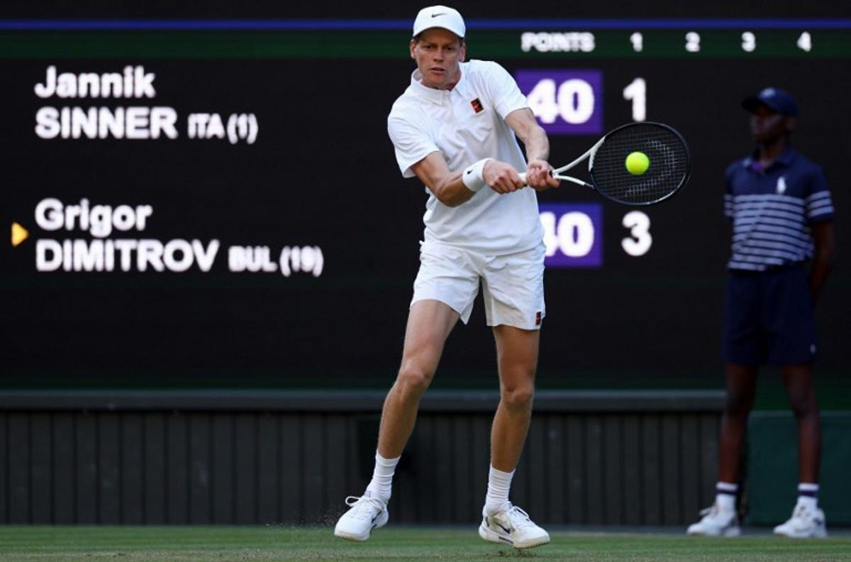 Italy's Jannik Sinner plays a backhand return to Bulgaria's Grigor Dimitrov during their men's singles fourth round tennis match on the eighth day of the 2025 Wimbledon Championships at The All England Lawn Tennis and Croquet Club in Wimbledon, southwest London, on July 7, 2025.  Adrian Dennis / AFP