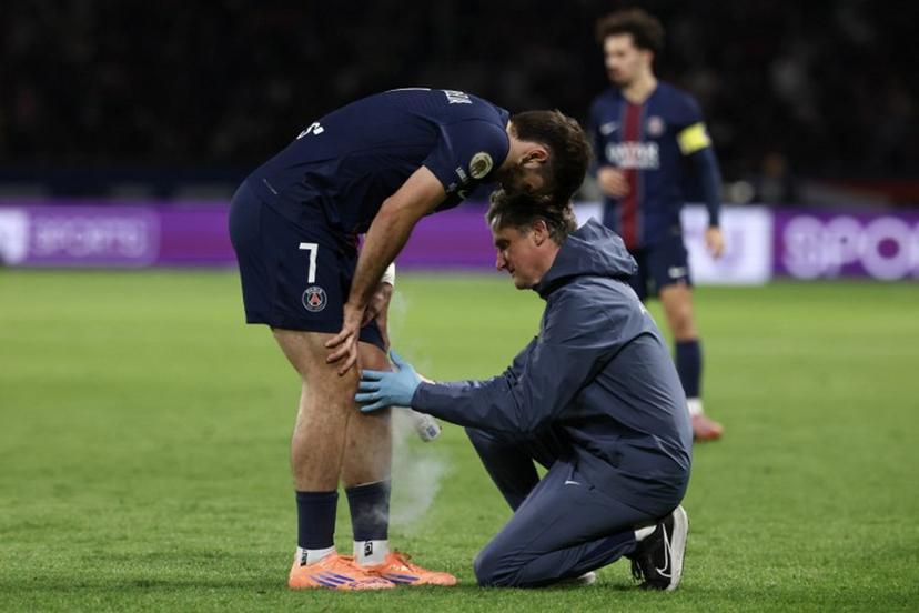 (FILES) Paris Saint-Germain's Georgian forward #07 Khvicha Kvaratskhelia receives medical assistance after suffering an injury during the French L1 football match between Paris Saint-Germain (PSG) and Auxerre at the Parc des Princes stadium in Paris on September 27, 2025. Kvaratskhelia, absent for the trip to Barcelona ahead of the UEFA Champions League first round day 2 football match.  FRANCK FIFE / AFP