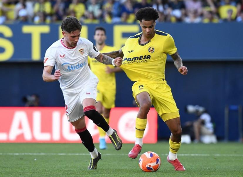 Sevilla's Spanish defender #02 Jose Carmona grasps Villarreal's Canadian midfielder #09 Tajon Buchanan's jersey during the Spanish league football match between Villarreal CF and Sevilla FC at La Ceramica Stadium in Vila-real, on May 25, 2025.  Jose Jordan / AFP