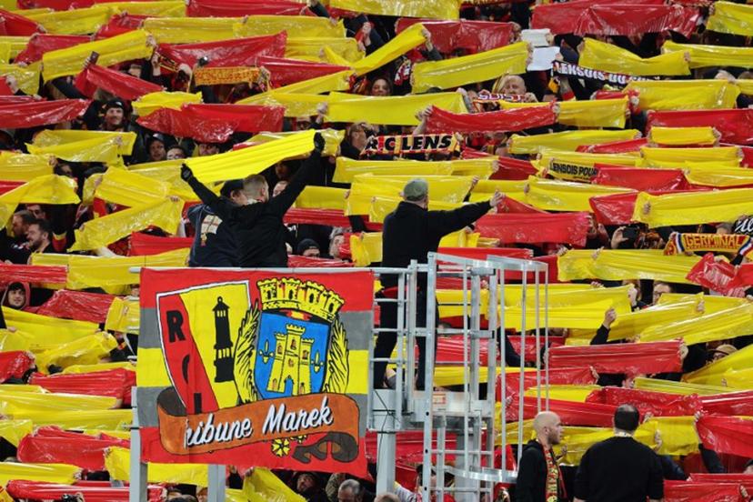 Lens supporters hold bands in the colours of the club before the UEFA Champions League Group B first leg football match between RC Lens and PSV Eindhoven at the Bollaert-Delelis stadium in Lens, northern France, on October 24, 2023.  FRANCOIS LO PRESTI / AFP