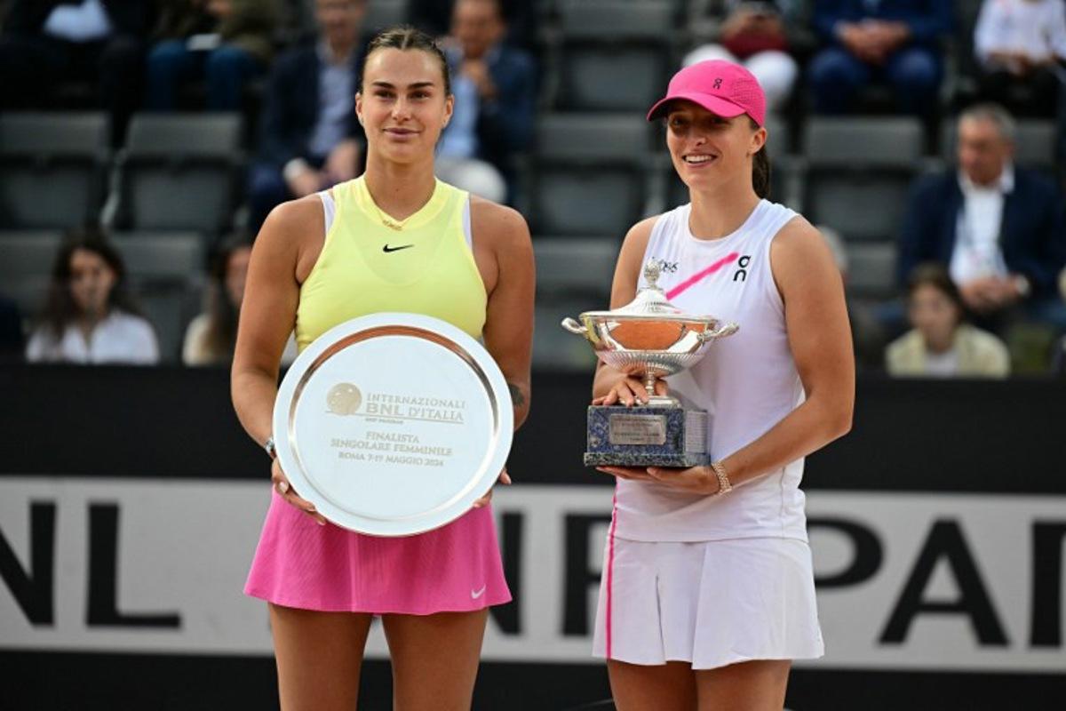 Poland's Iga Swiatek (R) poses with her trophy after winning the Women's final against Belarus' Aryna Sabalenka at the WTA Rome Open tennis tournament at Foro Italico in Rome on May 18, 2024.   Tiziana FABI / AFP