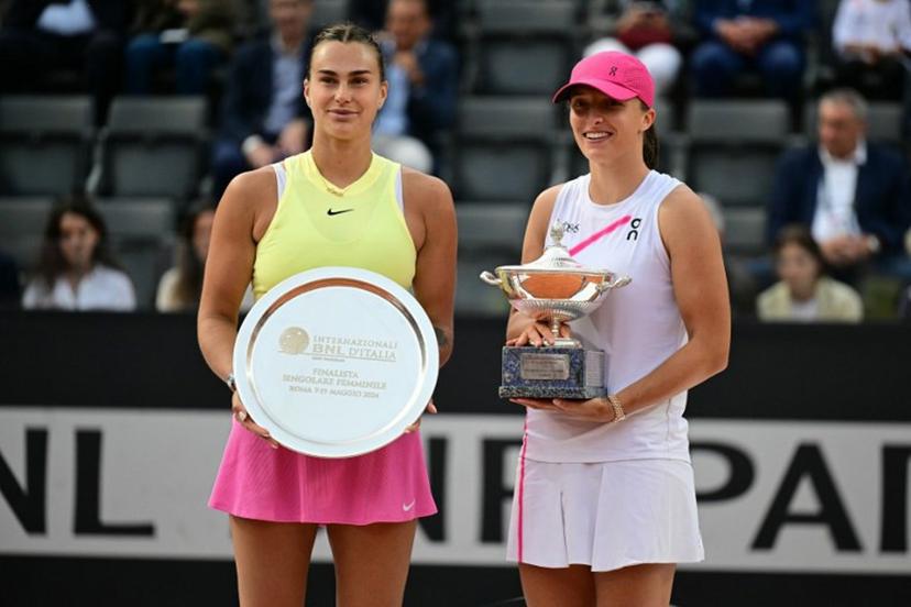 Poland's Iga Swiatek (R) poses with her trophy after winning the Women's final against Belarus' Aryna Sabalenka at the WTA Rome Open tennis tournament at Foro Italico in Rome on May 18, 2024.   Tiziana FABI / AFP