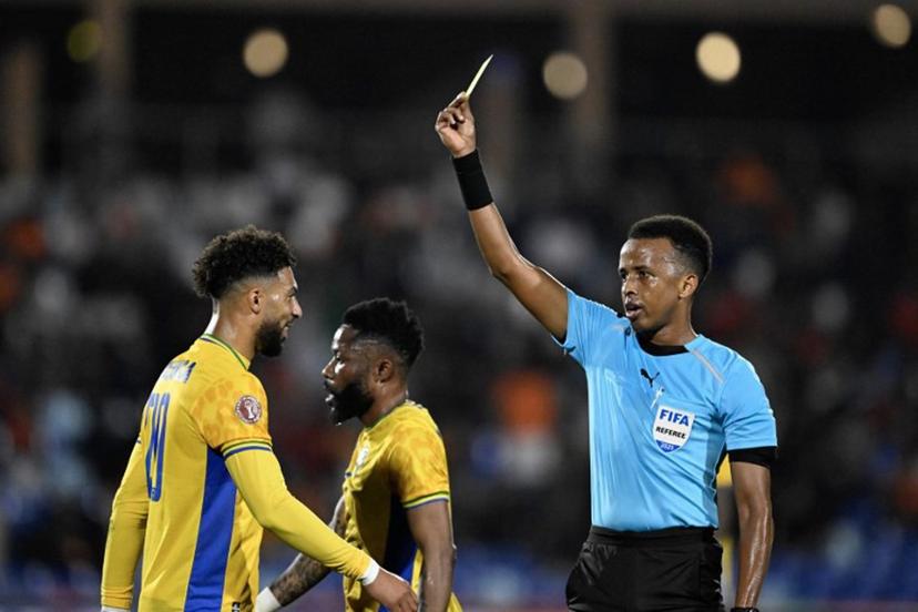 Gabon's forward #20 Denis Bouanga is shown the yellow card by Somali referee Omar Abdulkadir Artan during the Africa Cup of Nations (CAN) Group F football match between Gabon and Ivory Coast at the Grand Stadium in Marrakech on December 31, 2025.   Khaled DESOUKI / AFP