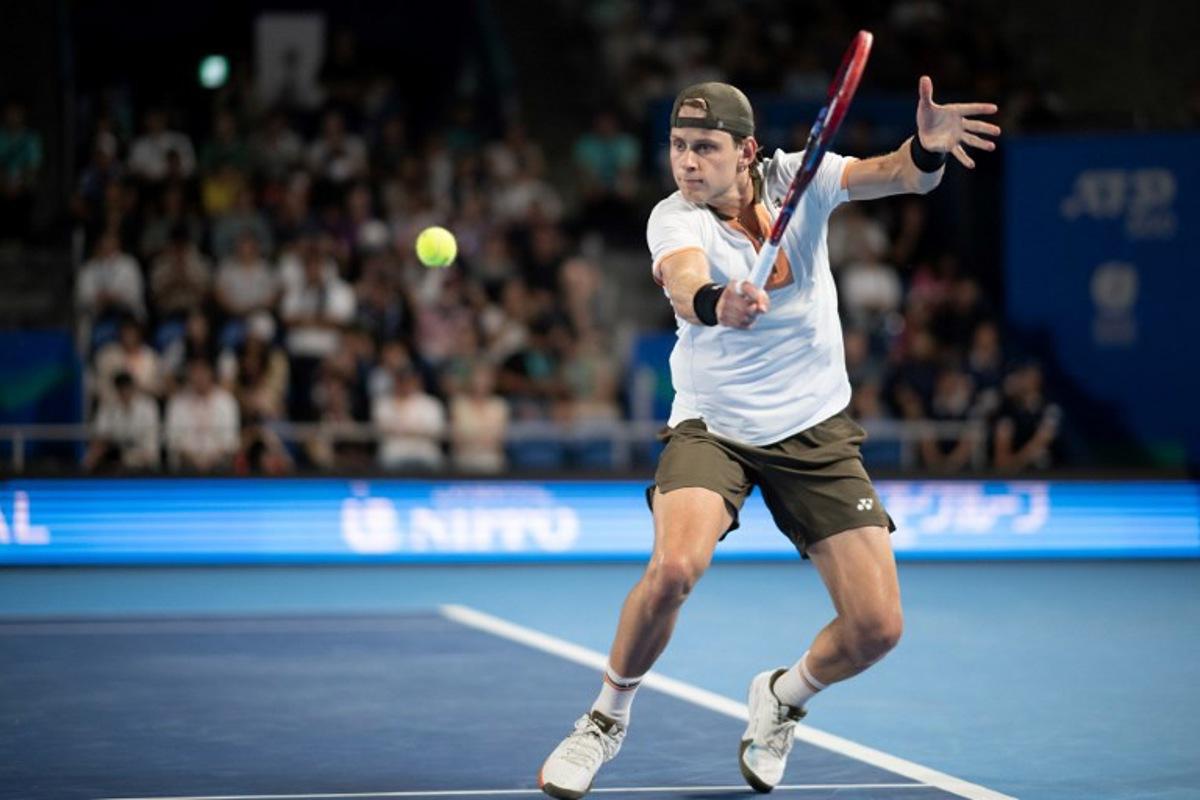 Belgium's Zizou Bergs hits a return against Spain's Carlos Alcaraz during their men's singles match at the ATP Japan Open tennis tournament in Tokyo on September 27, 2025.  Philip FONG / AFP