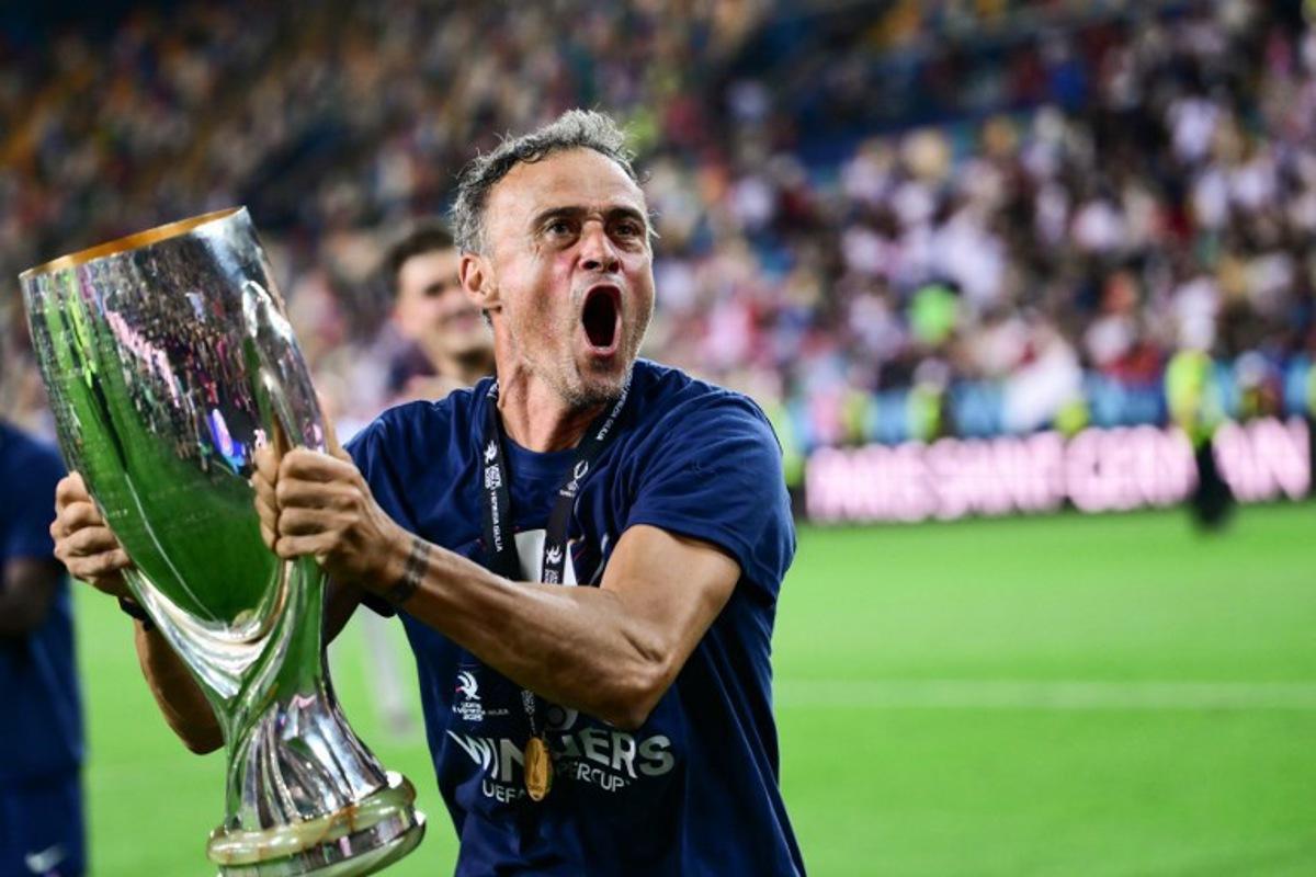 Paris Saint-Germain's Spanish headcoach Luis Enrique celebrates with the trophy after winning the 2025 UEFA Super Cup final football match between Paris Saint-Germain (FRA) and Tottenham Hotspur FC (ENG) at the Friuli stadium, in Udine, on August 13, 2025.  Marco BERTORELLO / AFP
