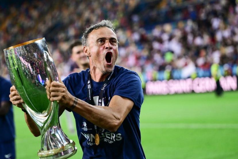 Paris Saint-Germain's Spanish headcoach Luis Enrique celebrates with the trophy after winning the 2025 UEFA Super Cup final football match between Paris Saint-Germain (FRA) and Tottenham Hotspur FC (ENG) at the Friuli stadium, in Udine, on August 13, 2025.  Marco BERTORELLO / AFP