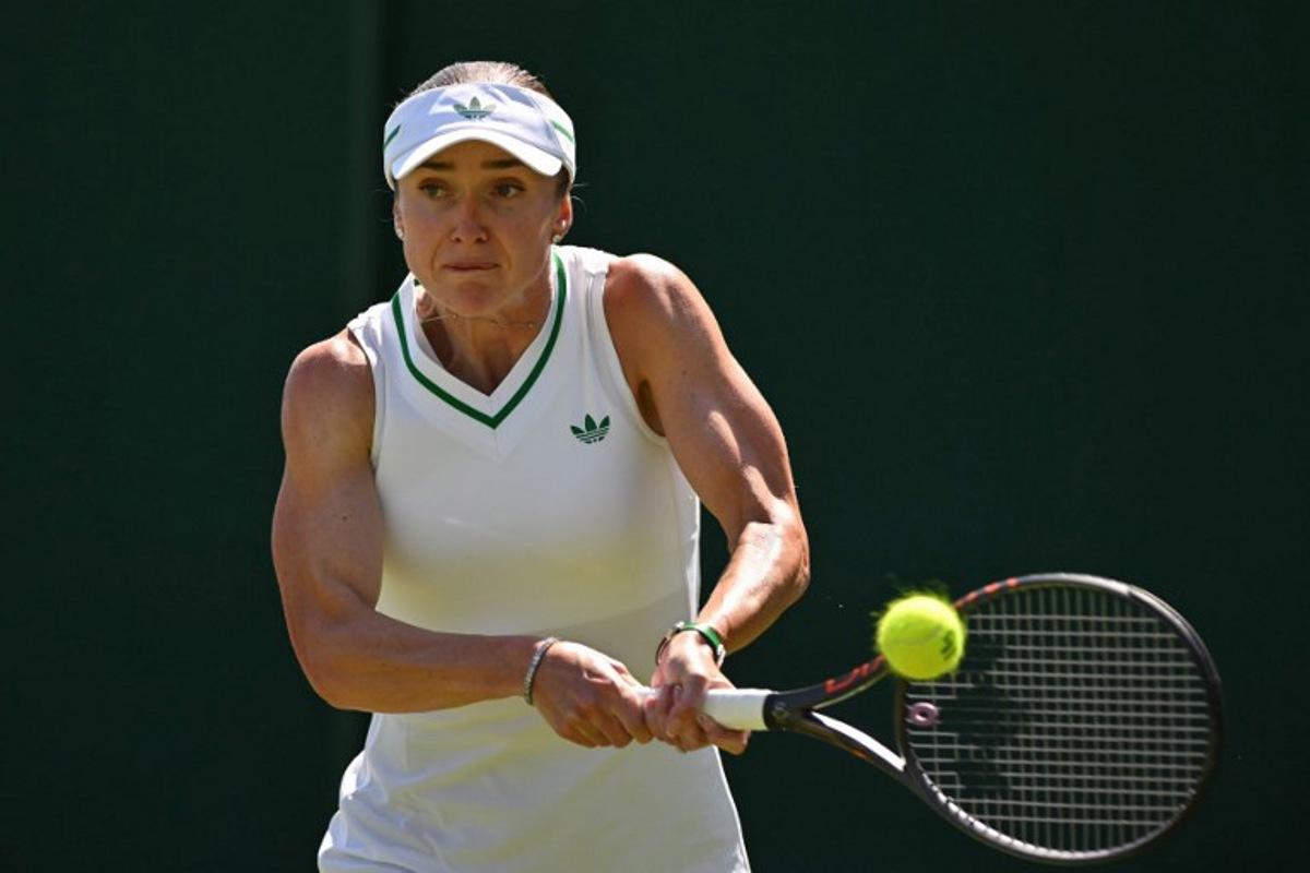 Ukraine's Elina Svitolina plays a backhand return to Hungary's Anna Bondar during their women's singles first round tennis match on the first day of the 2025 Wimbledon Championships at The All England Lawn Tennis and Croquet Club in Wimbledon, southwest London, on June 30, 2025.  Glyn KIRK / AFP