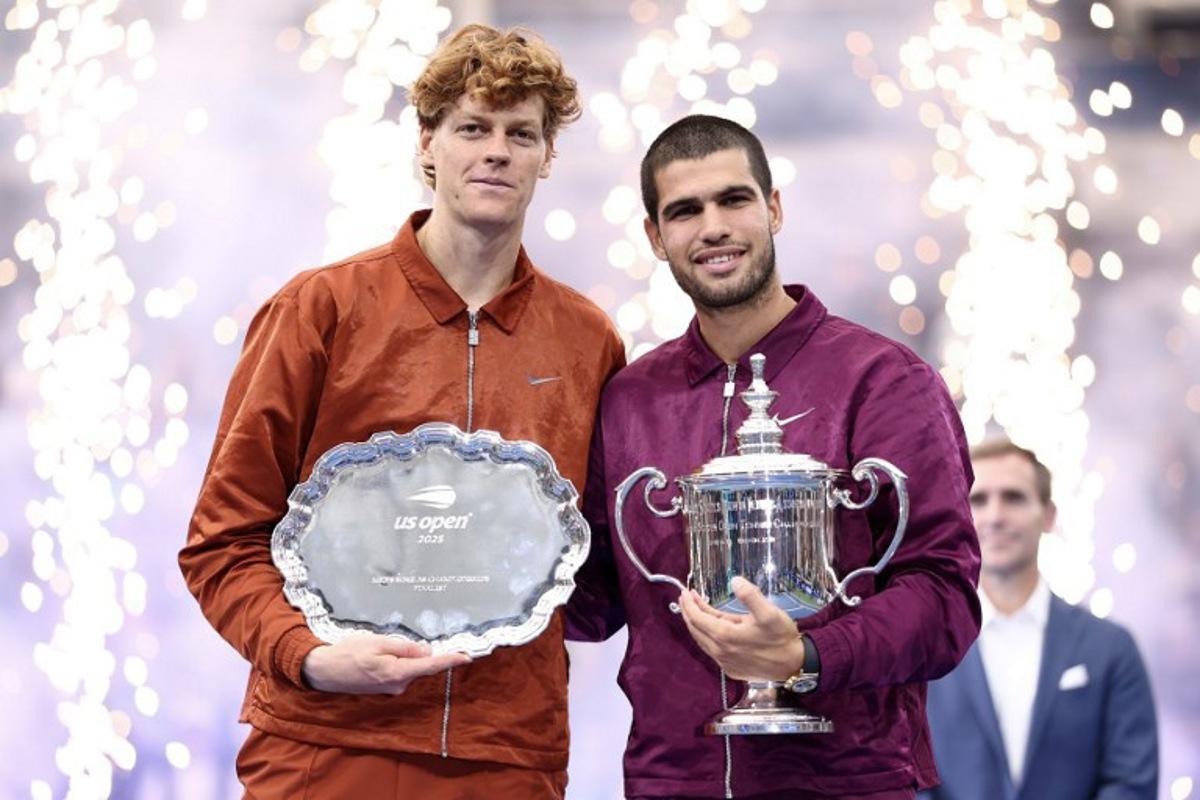Spain's Carlos Alcaraz (R) and Italy's Jannik Sinner (L) pose for a photo after their men's singles final tennis match on day fifteen of the US Open tennis tournament at the USTA Billie Jean King National Tennis Center in New York City, on September 7, 2025. Carlos Alcaraz beat Jannik Sinner in four sets on Sunday to win the US Open as loud boos -- mixed with a smattering of cheers -- greeted President Donald Trump at the final in New York.  CHARLY TRIBALLEAU / AFP