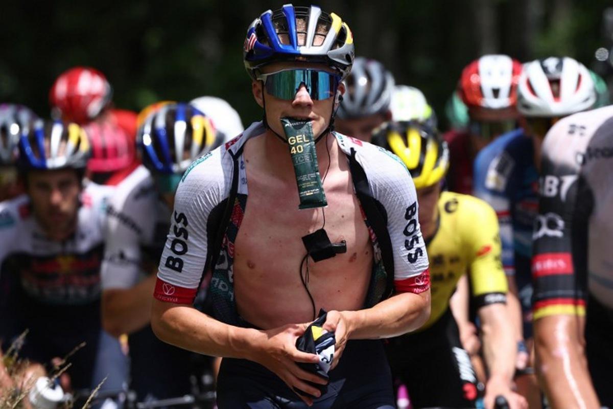 Red Bull - BORA - hansgrohe's Belgian rider Maxim Van Gils holds an energy gel in his mouth during the 7th stage of the 77th edition of the Criterium du Dauphine cycling race, 131,6 km between Grand-Aigueblanche and Valmeinier, on June 14, 2025.  Anne-Christine POUJOULAT / AFP