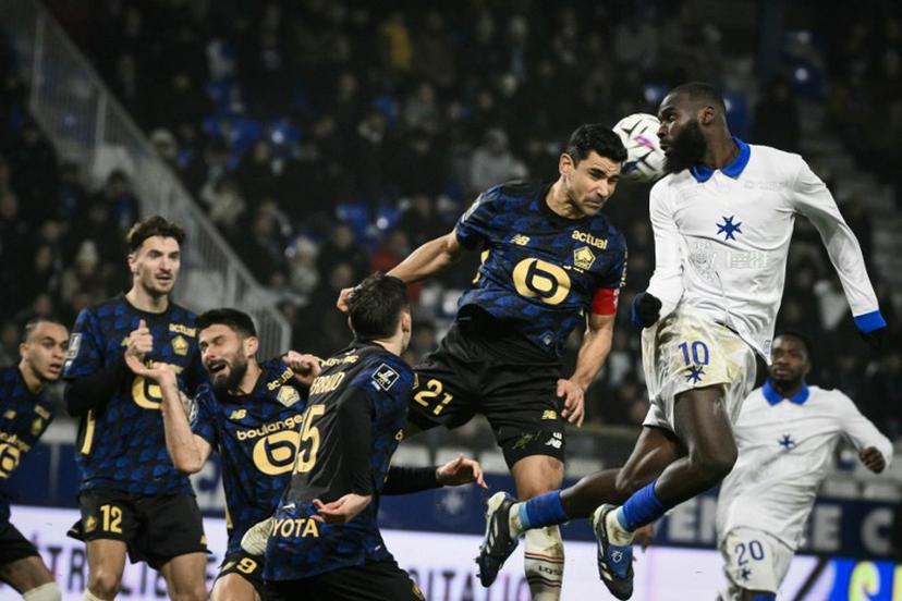 Auxerre's Malian forward #10 Lassine Sinayoko (R) fights for the ball with Lille's French midfielder #21 Benjamin Andre (3R)  during the French L1 football match between AJ Auxerre and Lille LOSC at the Stade de l'Abbe-Deschamps in Auxerre, central France, on December 14, 2025.  ARNAUD FINISTRE / AFP