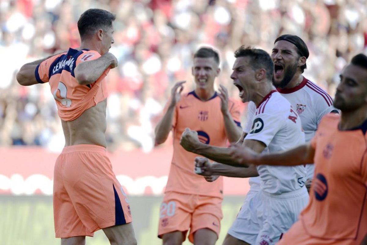 Barcelona's Polish forward #09 Robert Lewandowski (L) reacts to missing a penalty kick during the Spanish league football match between Sevilla FC and FC Barcelona at Ramon Sanchez Pizjuan Stadium in Seville on October 5, 2025.  CRISTINA QUICLER / AFP