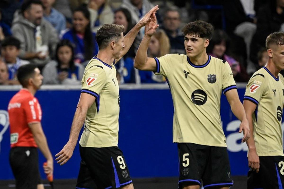 Barcelona's Polish forward #09 Robert Lewandowski (L) celebrates with teammate Barcelona's Spanish defender #05 Pau Cubarsi after scoring their second goal during the Spanish league football match between Real Oviedo and FC Barcelona at the Carlos Tartiere stadium in Oviedo on September 25, 2025.  Miguel RIOPA / AFP