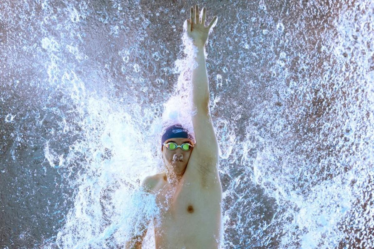 An underwater view shows China's swimmer Zhanle Pan as he competes in  a heat of the men's 100m freestyle swimming event during the 2025 World Aquatics Championships in Singapore on July 30, 2025.  FRANCOIS-XAVIER MARIT / AFP