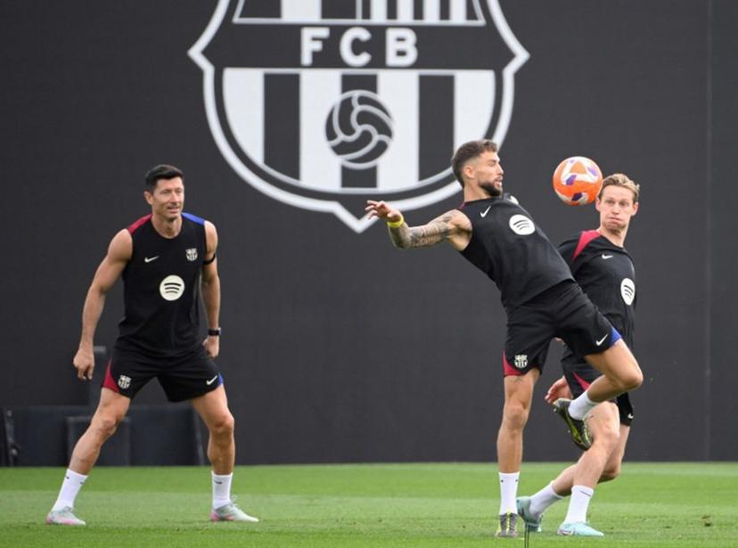 (From L) Barcelona's Polish forward #09 Robert Lewandowski, Barcelona's Spanish defender #05 Inigo Martinez Berridi, Barcelona's Dutch midfielder #21 Frenkie De Jong take part in a training session on the eve of the Spanish league football match between FC Barcelona and Real Madrid CF, at the Joan Gamper training ground in Sant Joan Despi, near Barcelona, on May 10, 2025.  Josep LAGO / AFP