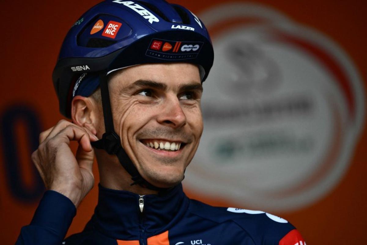 French rider of team PicNic Postnl, Warren Barguil, stands on stage before the start of the Milan - Sanremo one-day classic cycling race, in Pavia, near Milan, on March 22, 2025.  Marco BERTORELLO / AFP