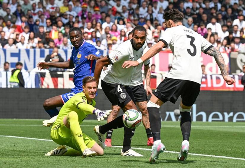 (L-R) France's forward #12 Randal Kolo Muani, Germany's goalkeeper #01 Marc-Andre Ter Stegen, Germany's defender #04 Jonathan Tah and Germany's defender #03 Robin Koch vie for the ball during the UEFA Nations League third place play-off football match between Germany and France in Stuttgart, southwestern Germany on June 8, 2025.  THOMAS KIENZLE / AFP