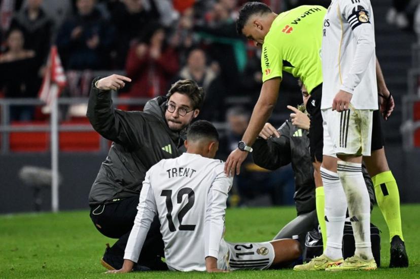 Real Madrid's English defender #12 Trent Alexander-Arnold receives medical assistance after sustaining an injury during the Spanish league football match between Athletic Club Bilbao and Real Madrid CF at the San Mames stadium in Bilbao on December 3, 2025.  ANDER GILLENEA / AFP