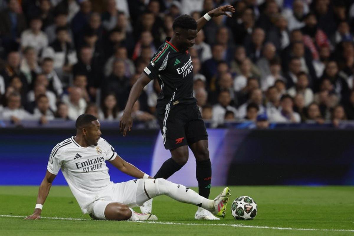 Real Madrid's Austrian defender #04 David Alaba and Arsenal's Ghanaian midfielder #05 Thomas Partey fight for the ball during the UEFA Champions League quarter final second leg football match between Real Madrid CF and Arsenal at Santiago Bernabeu Stadium in Madrid on April 16, 2025.  Pierre-Philippe MARCOU / AFP
