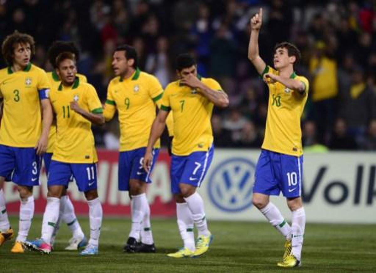 Brazilian midfielder Oscar (R) celebrates with teammates after scoring during the FIFA World Cup exhibition match between Italy and Brasil, March 21, 2012, at the stadium of Geneva . AFP PHOTO / FABRICE COFFRINI