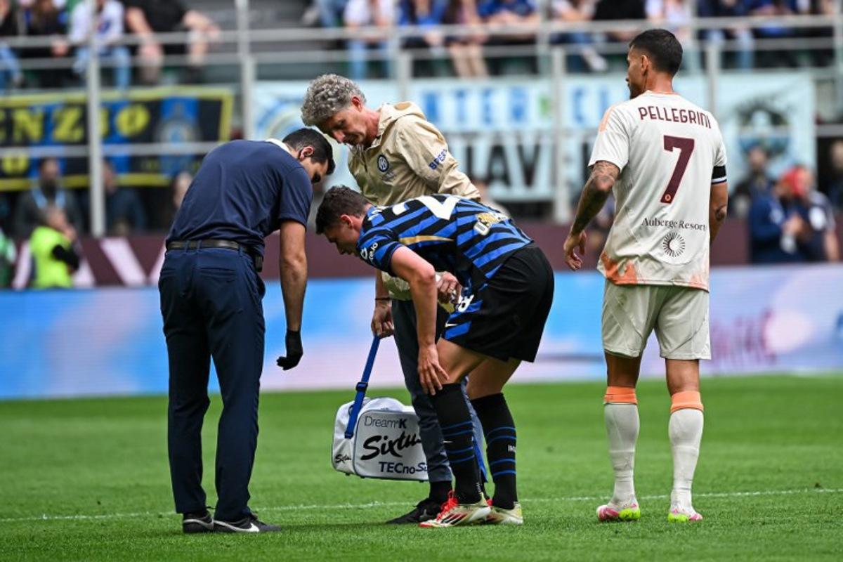Inter Milan's French defender #28 Benjamin Pavard (C) receives medical assistance after an injury during the Italian Serie A football match between Inter Milan and Roma at the San Siro stadium in Milan on April 27, 2025.  Piero CRUCIATTI / AFP