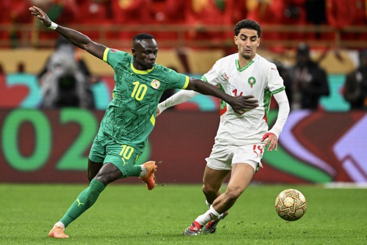 Senegal's forward #10 Sadio Mane and Morocco's midfielder #14 Oussama Targhalline vie during the Africa Cup of Nations (CAN) final football match between Senegal and Morocco at the Prince Moulay Abdellah Stadium in Rabat on January 18, 2026.   SEBASTIEN BOZON / AFP