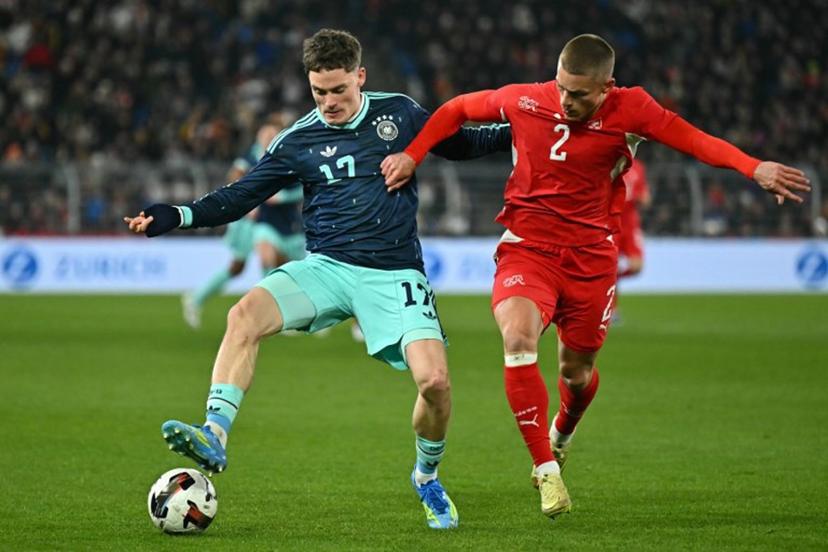 Germany's midfielder #17 Florian Wirtz fights for the ball with Switzerland's defender #2 Miro Muheim during the international friendly football match between Switzerland and Germany at St. Jakob-Park in Basel, Switzerland on March 27, 2026.  Fabrice COFFRINI / AFP