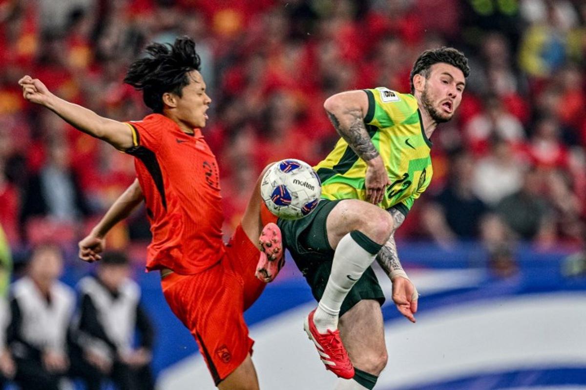 China's Wang Haijian (L) competes for the ball with Australia's Aiden O'Neill (Center, R) during the 2026 FIFA World Cup qualification football match between China and Australia at the Hangzhou Olympic Sports Center Stadium in Hangzhou, in China's eastern Zhejiang province on March 25, 2025.  Hector RETAMAL / AFP