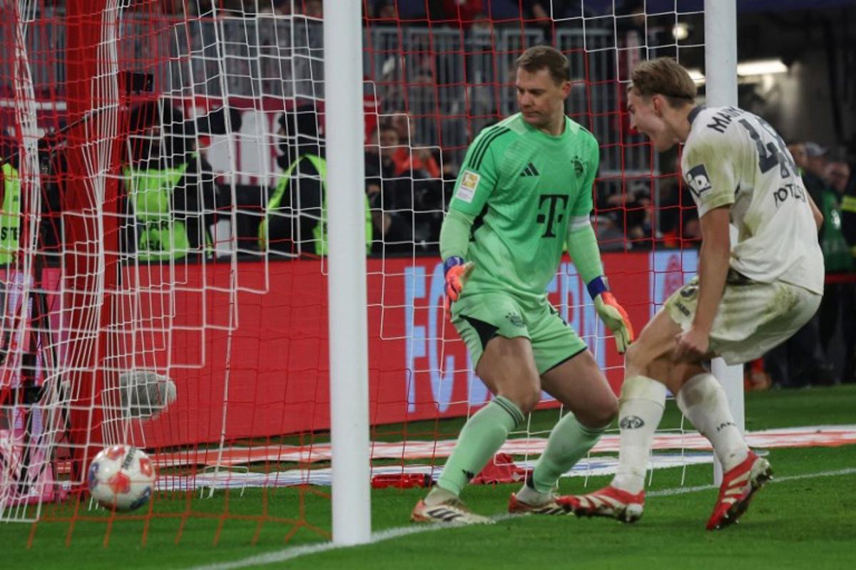 Mainz' Polish defender #48 Kacper Potulski (R) scores the 1-1 goal past Bayern Munich's German goalkeeper #01 Manuel Neuer during the German first division Bundesliga football match between FC Bayern Munich and Mainz 05 in Munich, southern Germany on December 14, 2025.  Karl-Josef HILDENBRAND / AFP