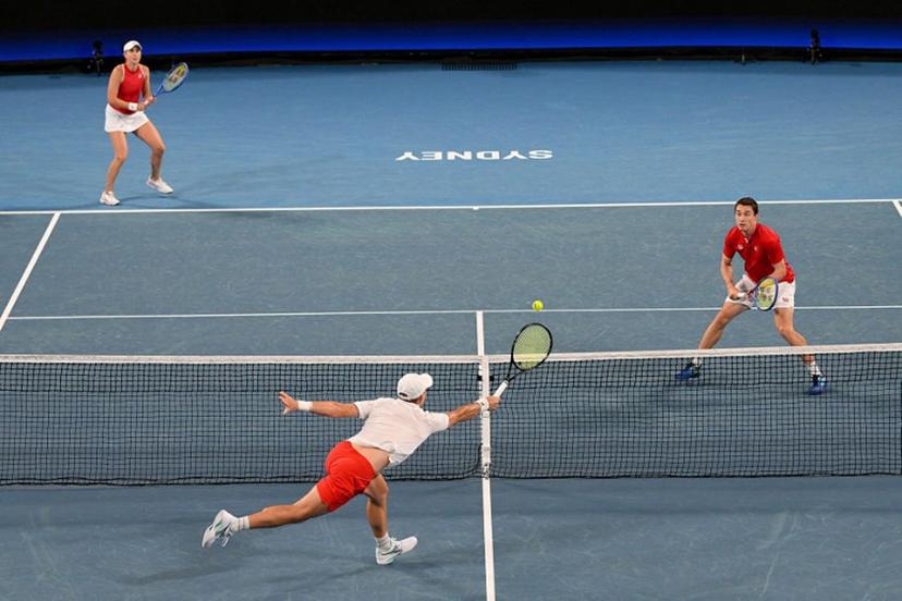 Poland's Jan Zielinski hits a return against Switzerland's Jakub Paul and Belinda Bencic during their mixed doubles match during the final at the United Cup tennis tournament in Sydney on January 11, 2026.   Izhar KHAN / AFP