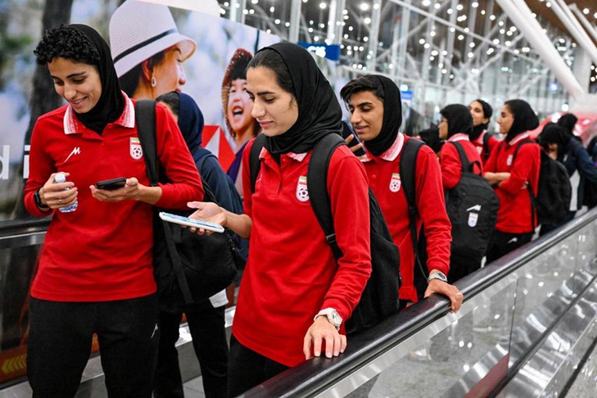 Members of Iran's women's football team walk as they arrive at the Kuala Lumpur International Airport after taking part in the AFC Women's Asian Cup Australia 2026 tournament in Australia, in Sepang on March 11, 2026. At least five players from Iran's visiting women's football team claimed asylum in Australia on on March 10, seeking protection after they were branded "traitors" at home for refusing to sing the national anthem.  Mohd RASFAN / AFP
