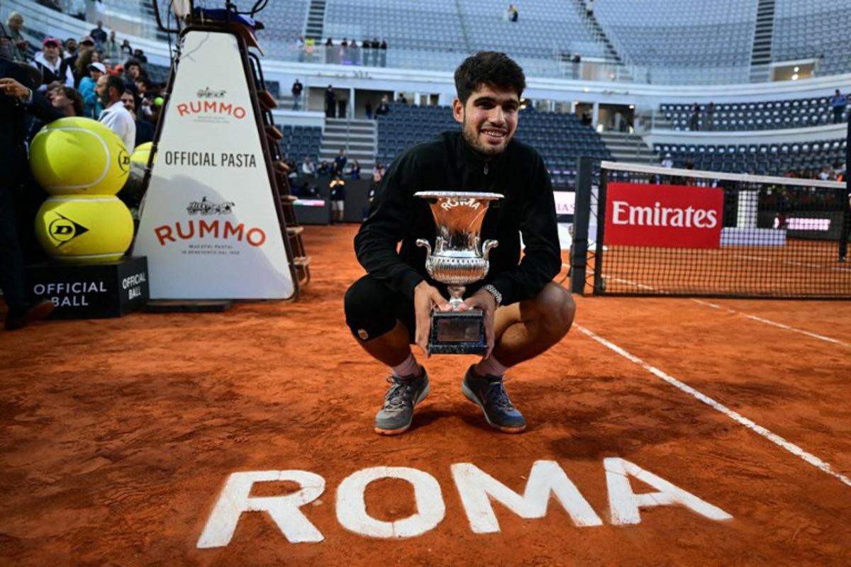 Spain's Carlos Alcaraz poses with his winner trophy at the end of his men's singles final match against Italy's Jannik Sinner for the ATP Rome Open tennis tournament at Foro Italico in Rome on May 18, 2025.   Tiziana FABI / AFP