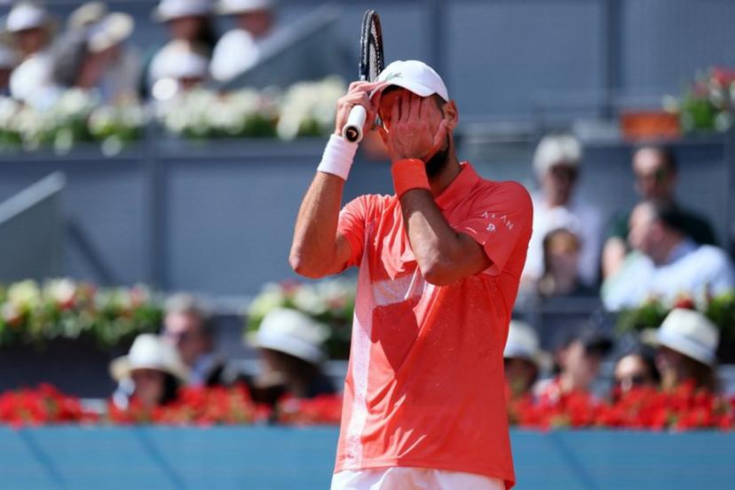 Serbia's Novak Djokovic wipes his face as he plays against Italy's Matteo Arnaldi  during their 2025 ATP Tour Madrid Open tennis tournament second round singles match at the Caja Magica in Madrid, on April 26, 2025.  Thomas COEX / AFP
